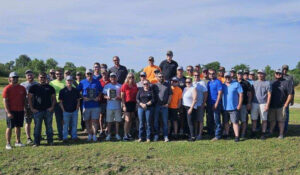 A group of adults standing in an open field