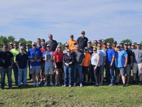 A group of adults standing in an open field