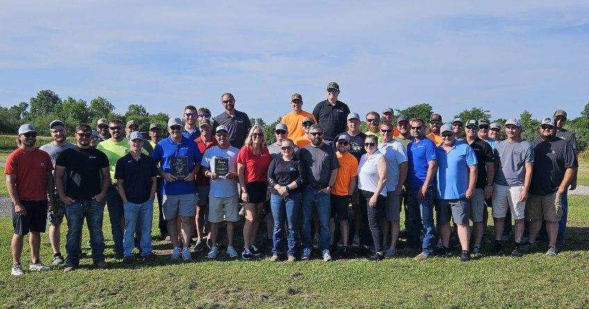 A group of adults standing in an open field