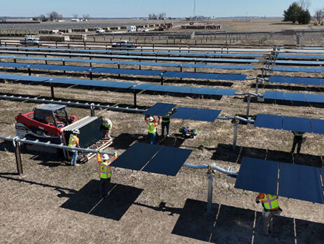 Construction workers install solar panels in a solar field