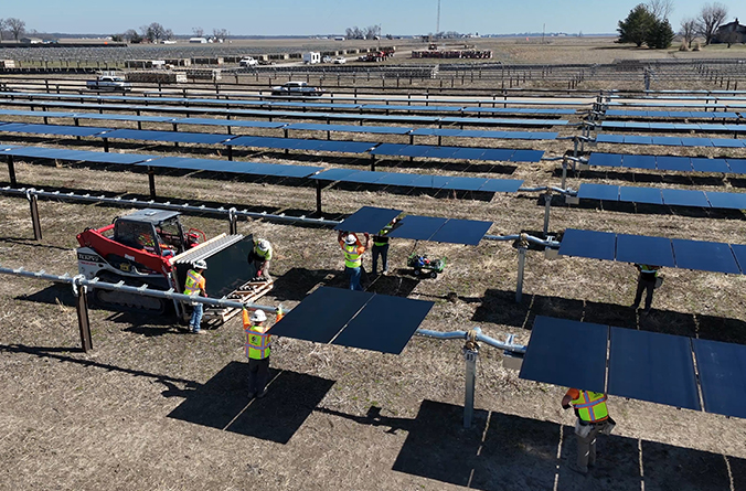 Construction workers install solar panels in a solar field