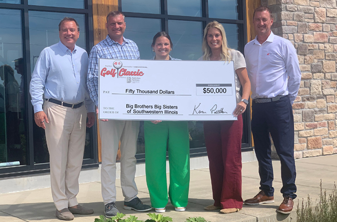 Three men and a woman present a giant check to another woman
